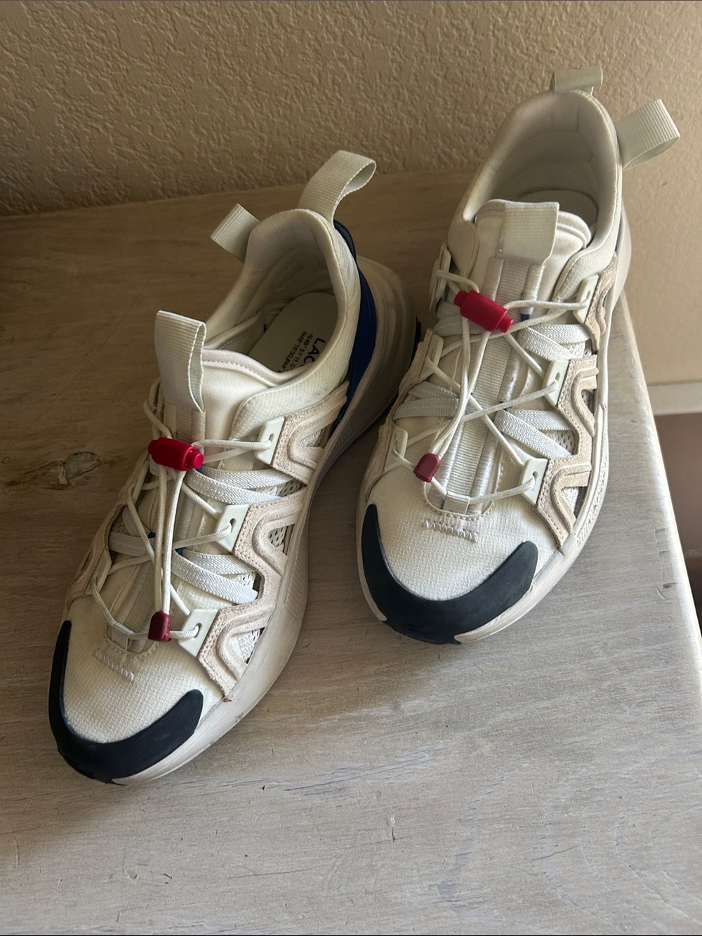 Lacoste Men's Cream Athletic Sneakers with Black and Red Accents